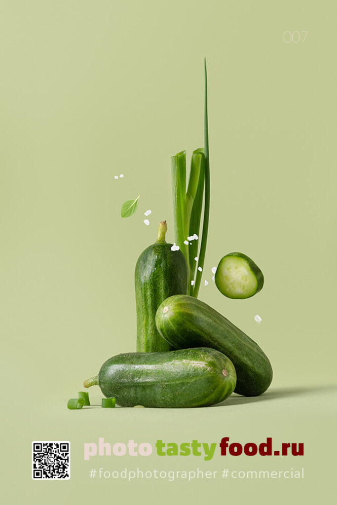 Cucumbers and green onions with a sprinkle of salt, presented on a light green background for a refreshing look. Фуд фотограф | food photographer. Огурцы и зеленый лук с щепоткой соли на светло-зеленом фоне придают блюду освежающий вид.